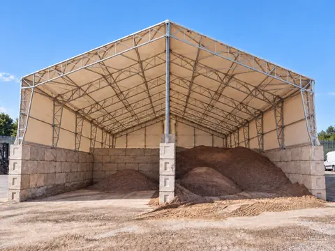 An open sided canopy covering aggregate storage bays